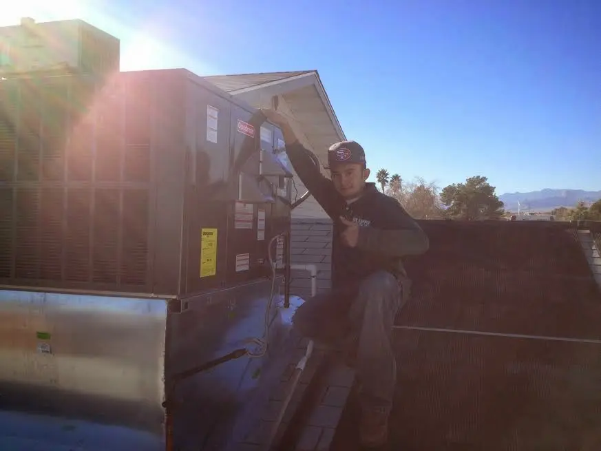HVAC technician performing Air Duct Repair on a rooftop unit in Templeton